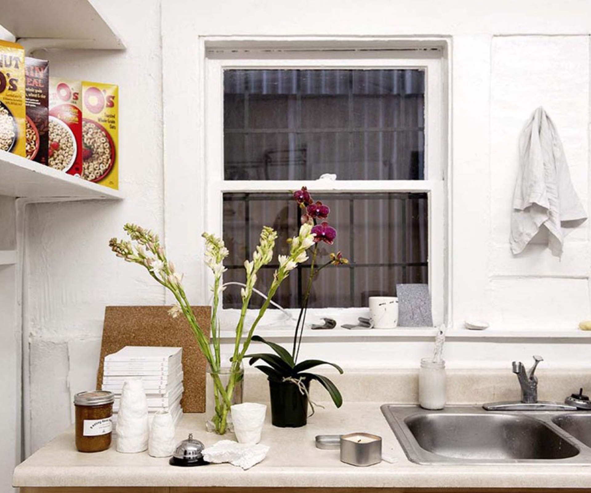 Cereal boxes and flowers in the kitchen. 