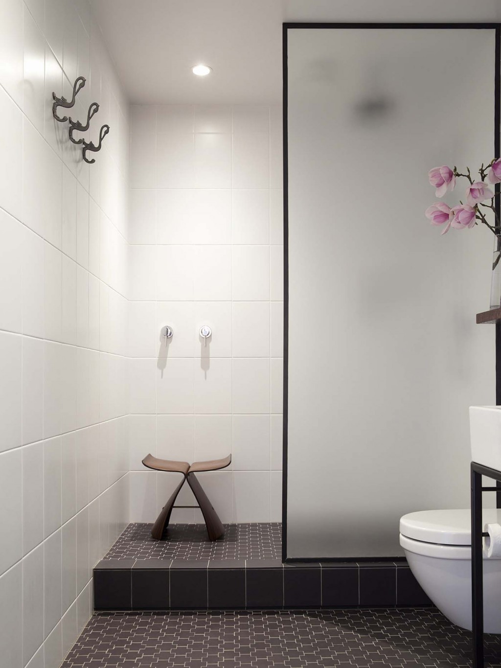 The bathroom - a windowless space in Carroll's small apartment - now features Deco-flavoured floor tiles and a simple shower area. Photograph by David Straight.