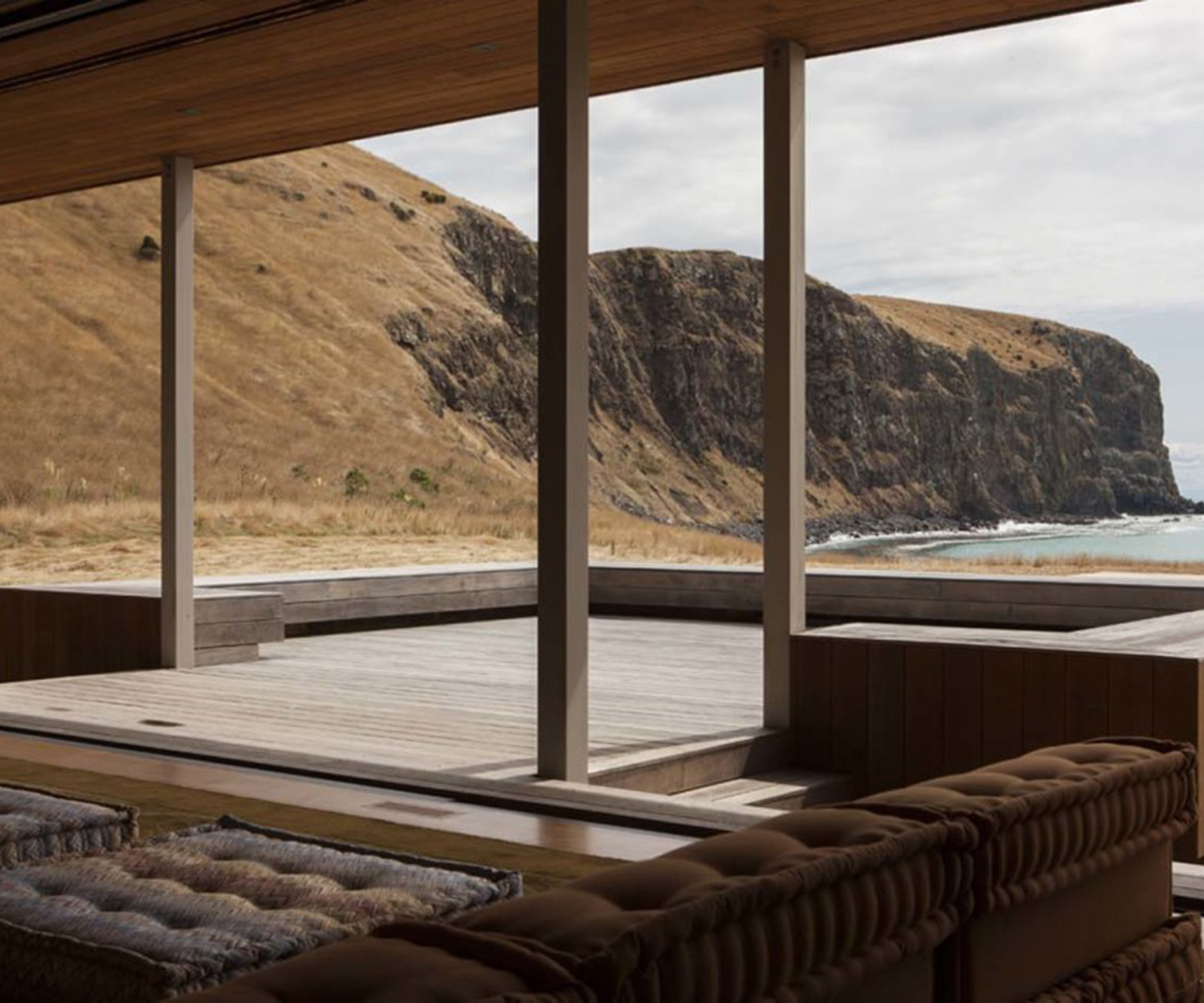 The living room opens onto a large north-facing deck with a view of the ocean. 