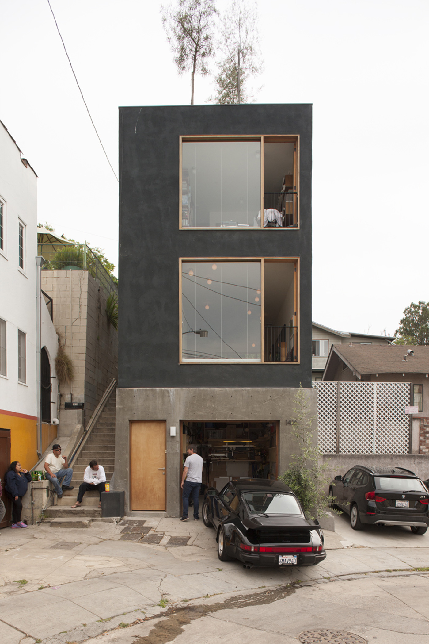 Architect Simon Storey chats to his neighbours outside his Los Angeles home. When the car's out on the pavement he uses the space as a workshop. Photograph by Simon Devitt.
