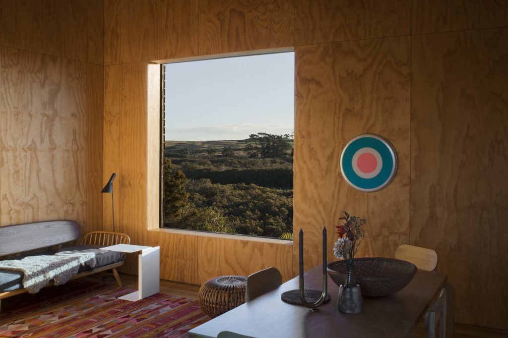 One of the cabins has a plain ply interior. The sofa is by Ercol, the 'AJ' floor lamp is by Arne Jacobsen and the artowkr is by Julian Dashper. Photograph by Darryl Ward. 