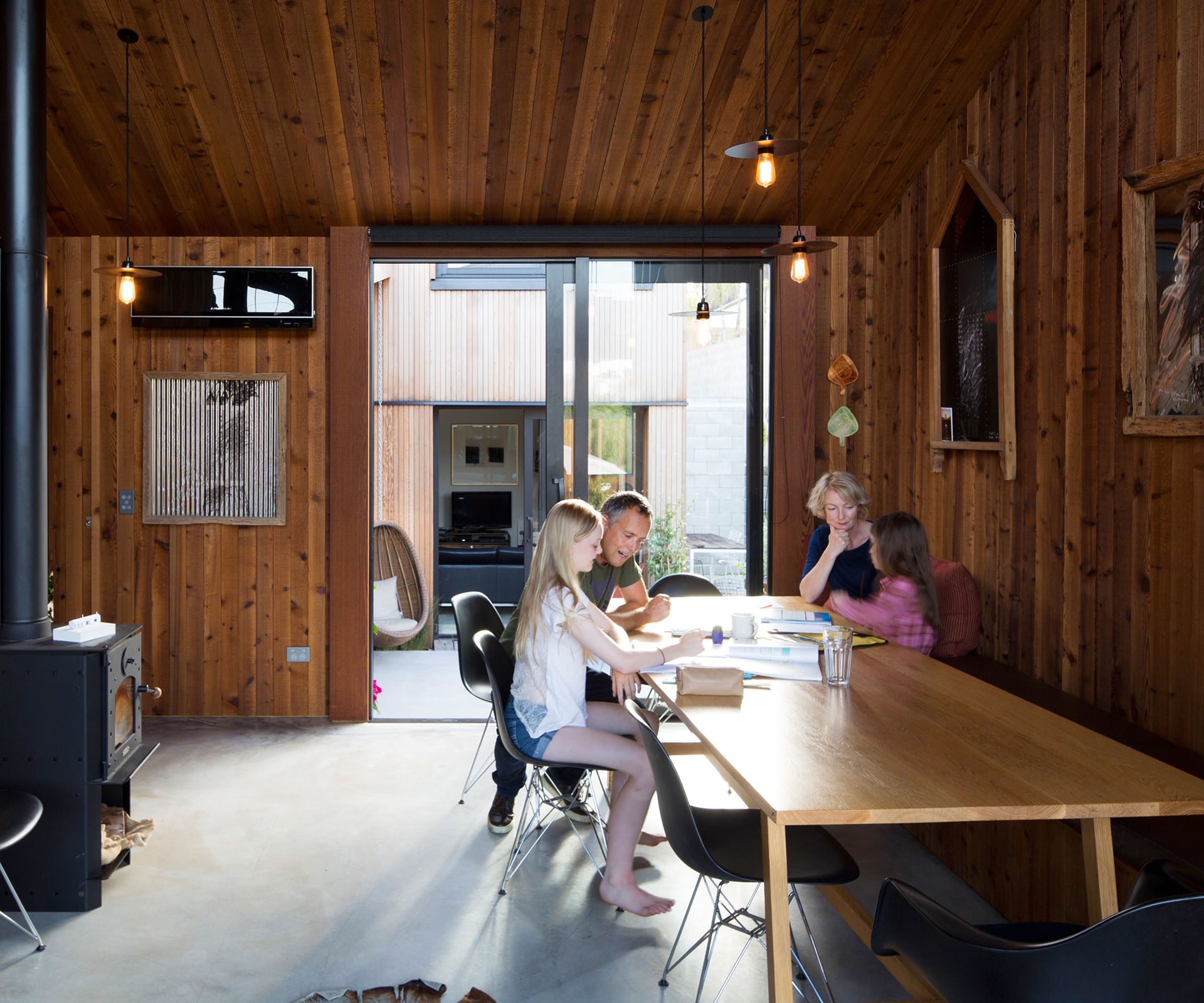 The home's living areas are clad in knotty, fragrant cedar. Here, the kitchen and dining room looks out onto one of the home's courtyards. Photograph by Patrick Reynolds.