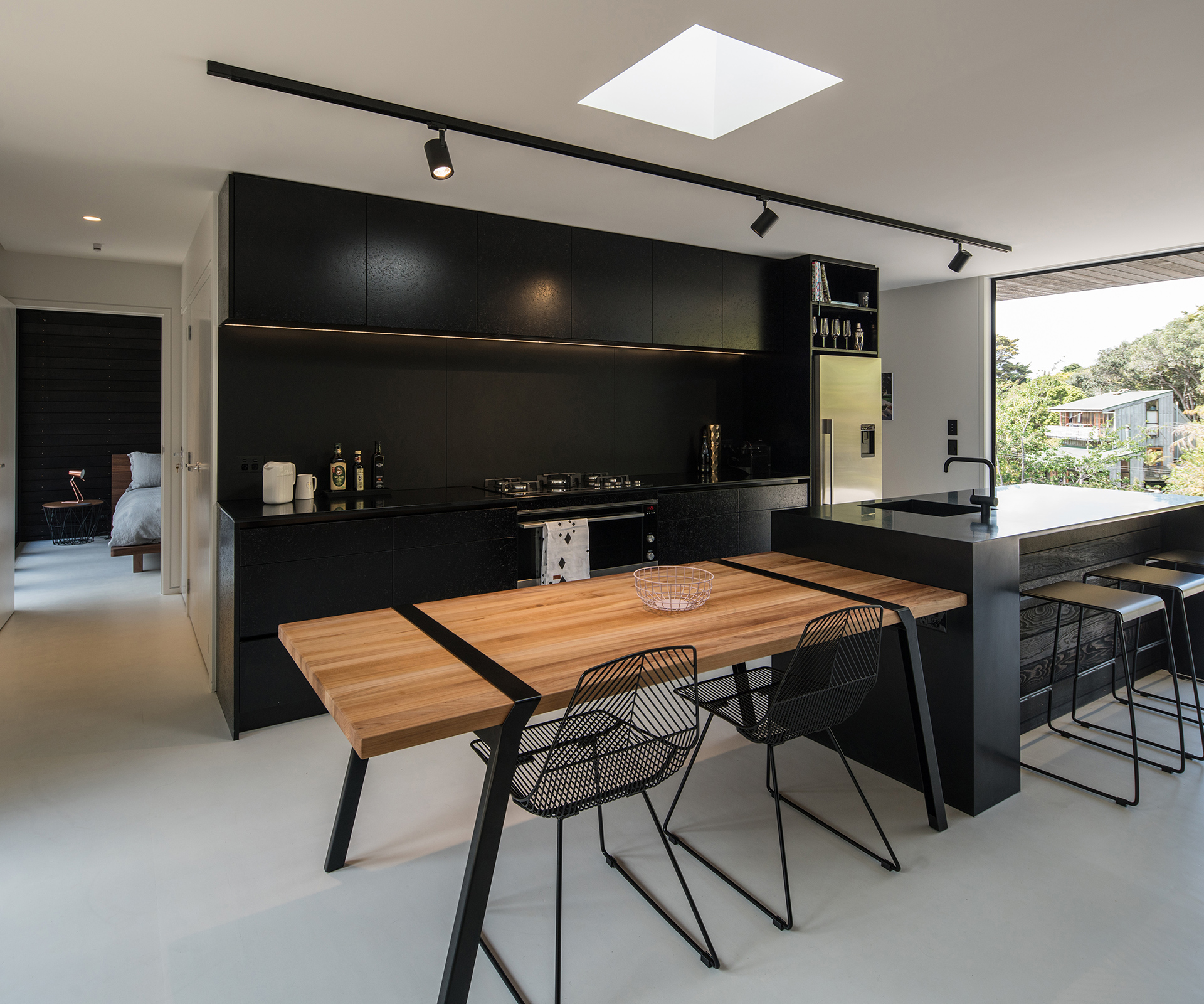 This view of the kitchen shows a glimpse of the home's guest bedroom. Photograph by Jeremy Toth. 