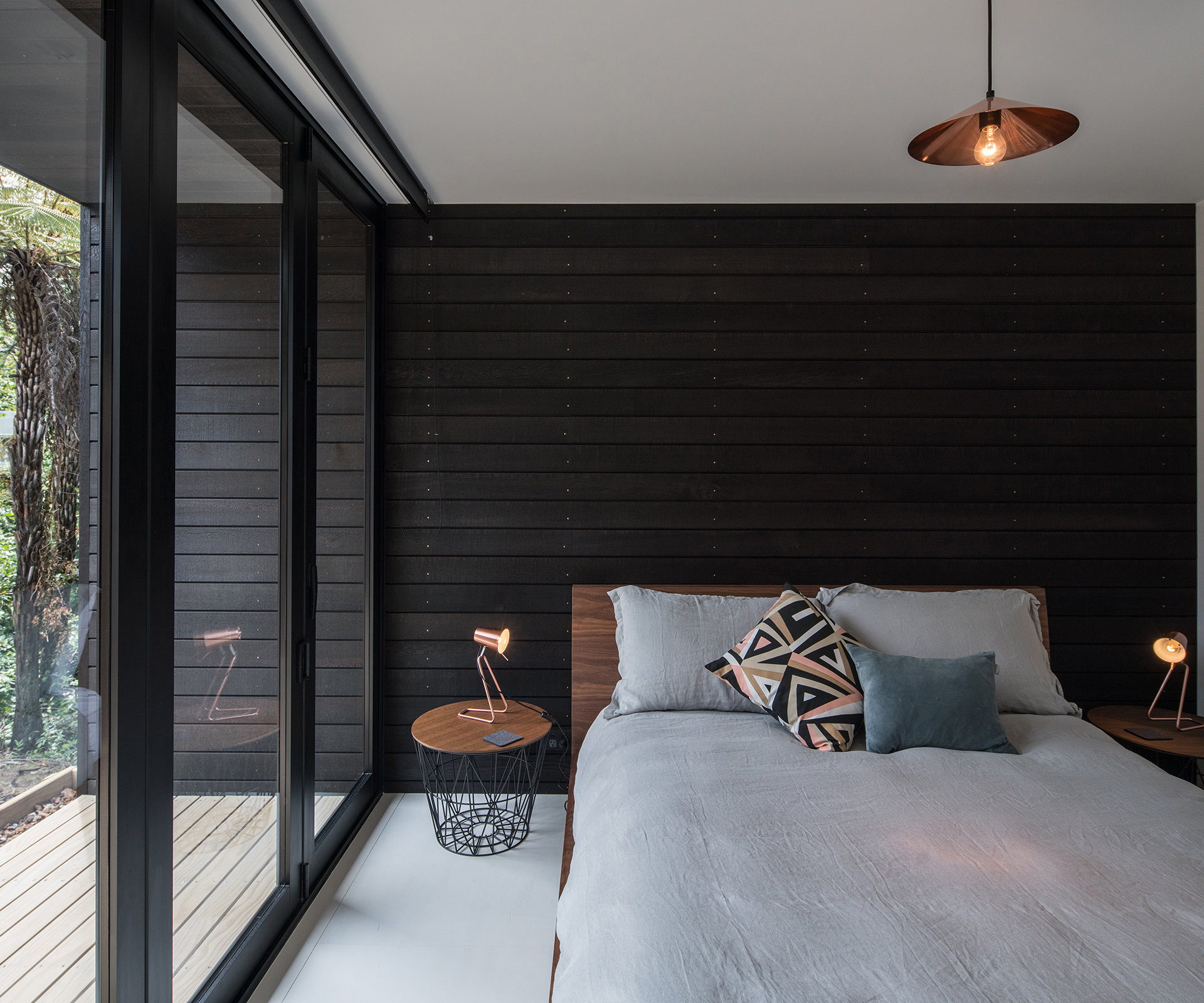 The guest bedroom opens onto the rear deck of the home. Photograph by Jeremy Toth. 