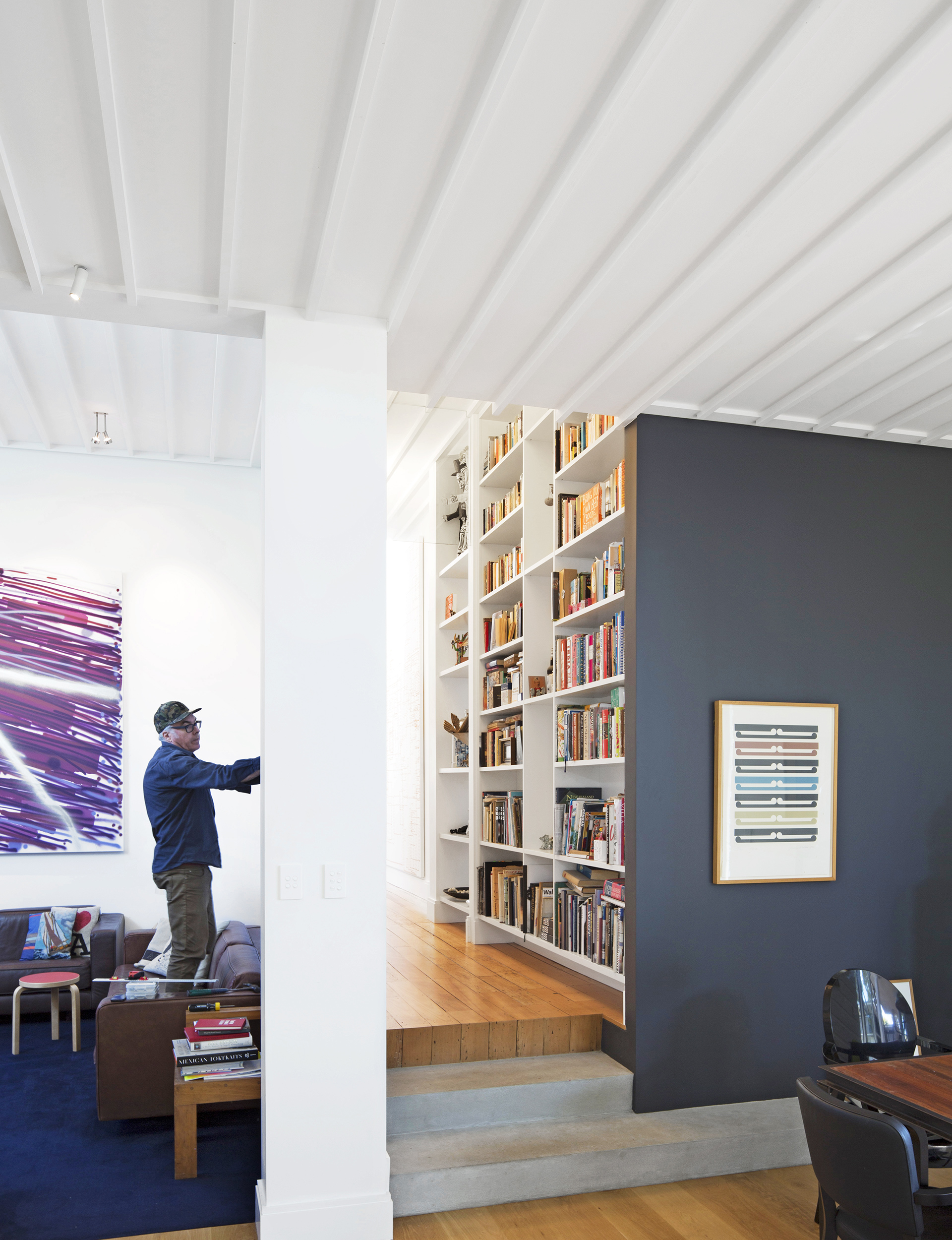Dropping the living area down a few steps has increased its lofty proportions. On the wall next to John is his work ‘The Second Fall’ (2010). 