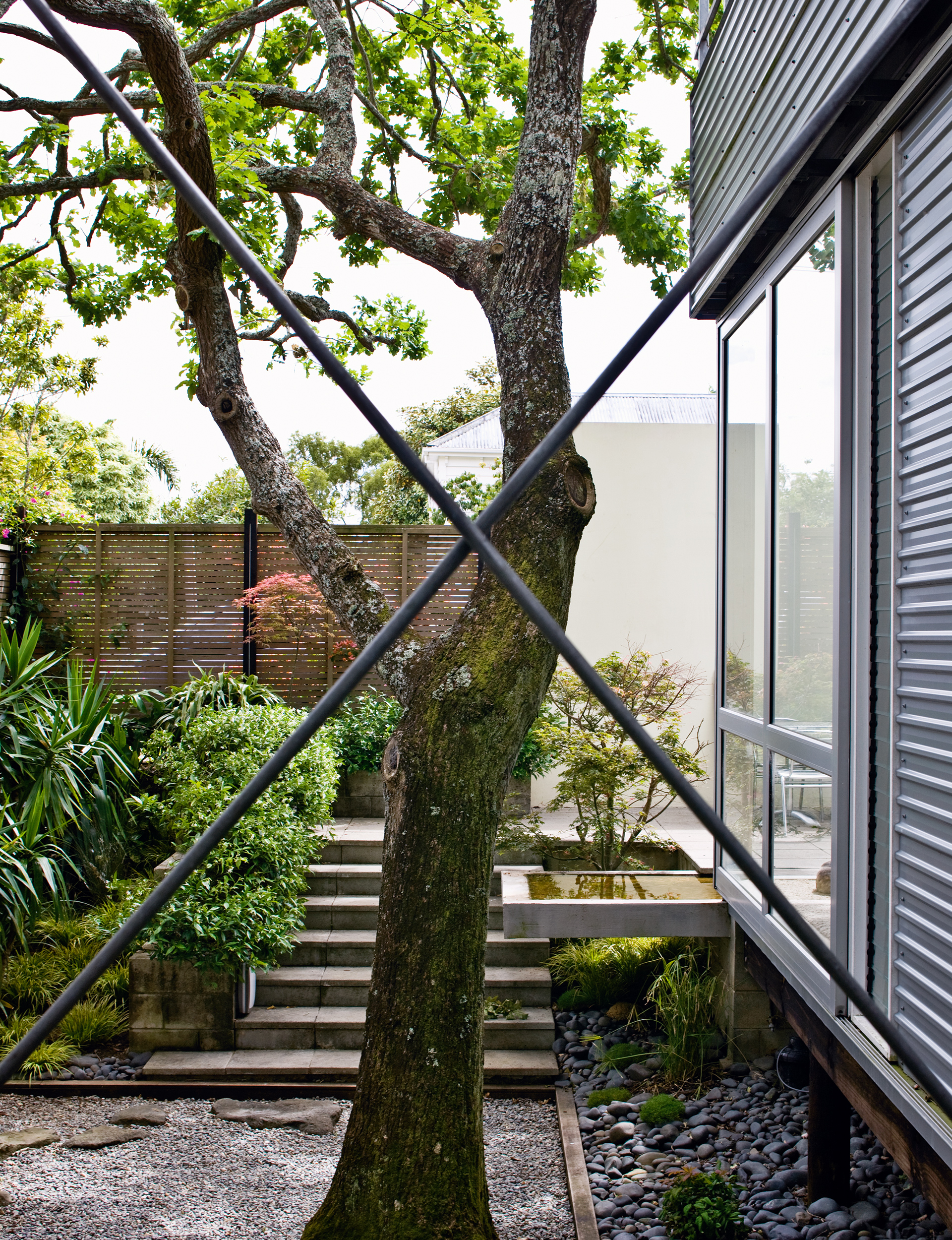 Steel beams cross over on the deck outside the living area of the home.