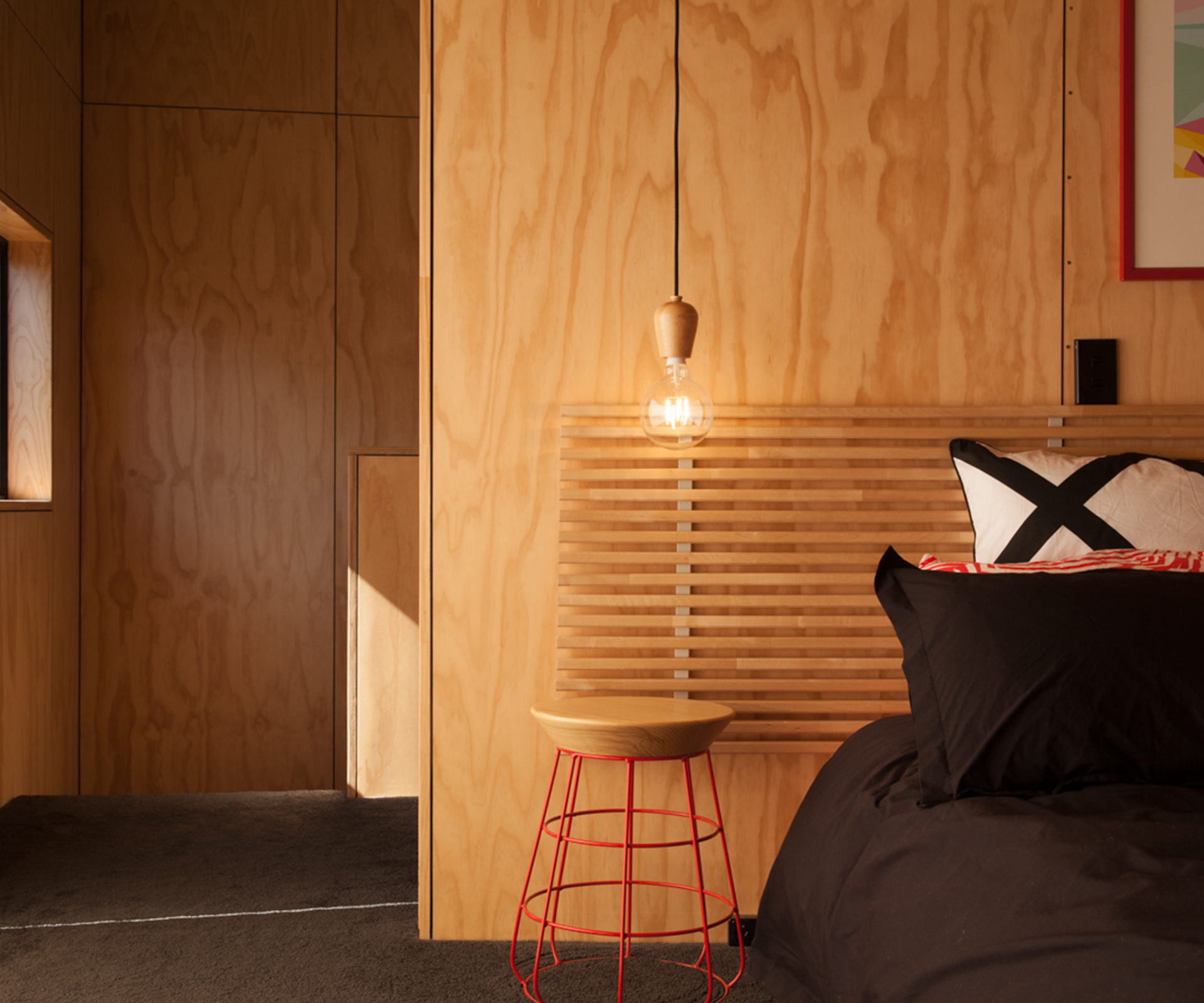 A stool by Timothy John beside the bed in the main bedroom.