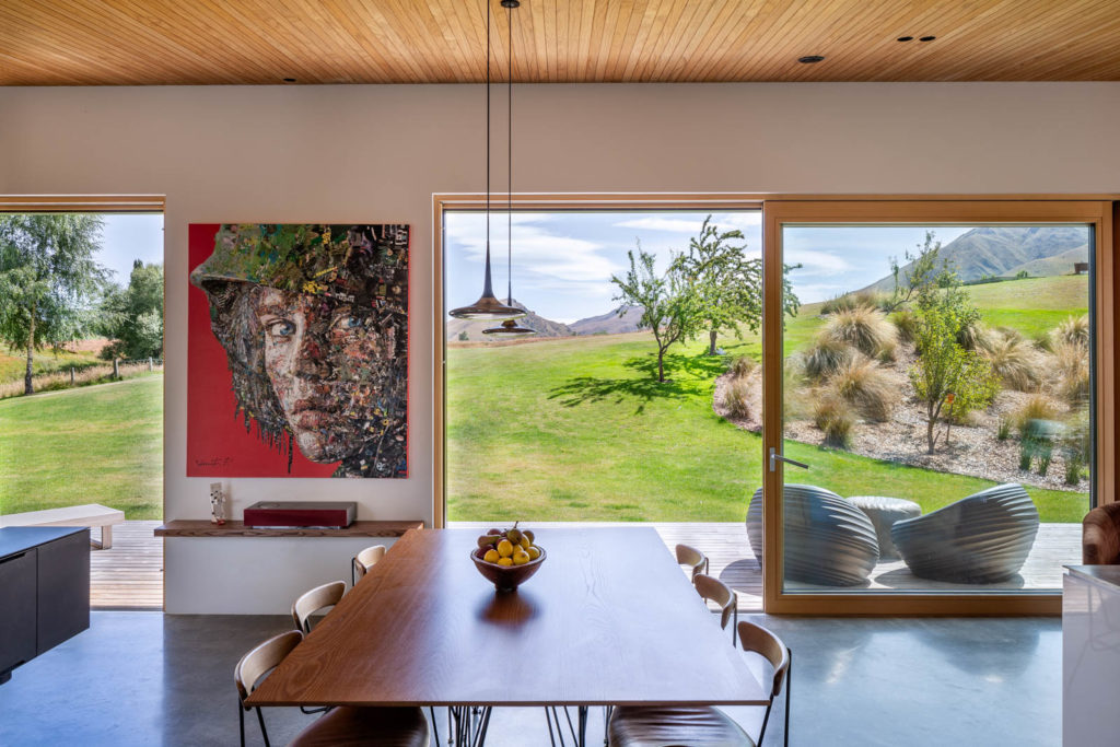 A view from the dining room out toward rolling green hills.