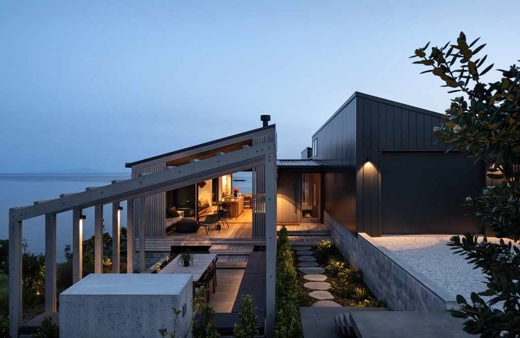 a nighttime view of the home from outside with social dining area and view of the living area